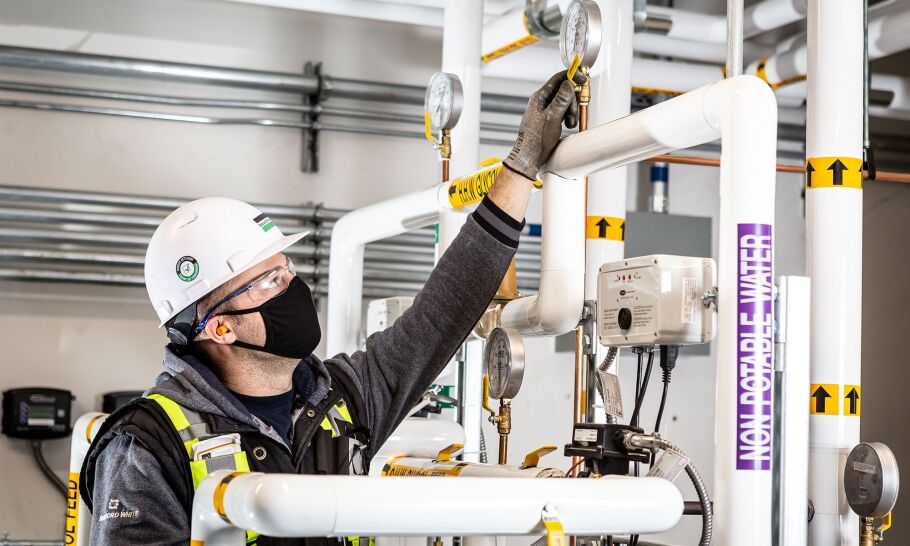 A B&M service technician recording meter readings at a client site.