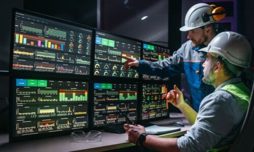 Deux opérateurs d'installation vérifiant et analysant le processus sur des écrans